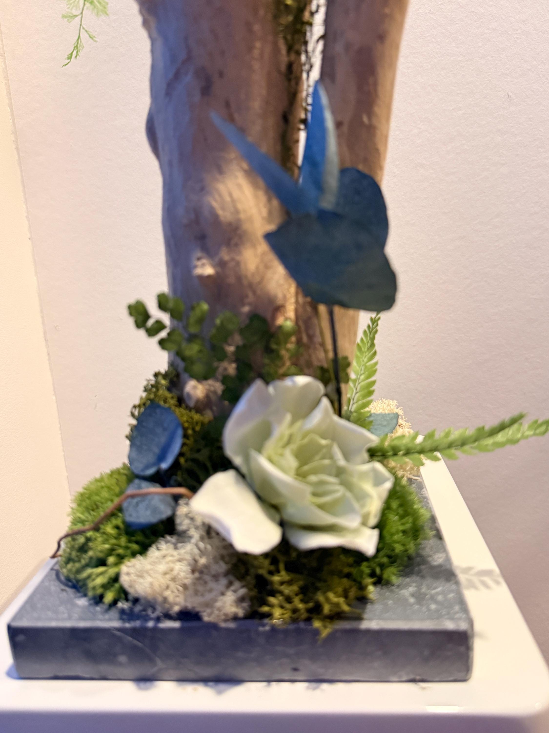 Décoration végétale sur bois flotté  Fleur de gardénia stabilisée, eucalyptus & mousse  Centre de table naturel haut de gamme